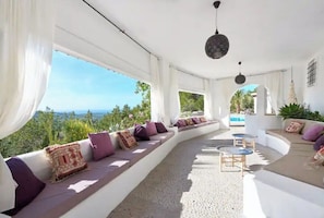 A sunlit interior with a curved seating area, a pool visible through the windows, and a view of the landscape. - LOOK NO FURTHER! Gorgeous old finca with sea view! (Sant Joan de Jabritja)