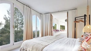 A spacious bedroom with a large bed, a view of the outdoors, and a balcony. - LOOK NO FURTHER! Gorgeous old finca with sea view! (Sant Joan de Jabritja)