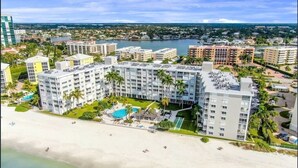 Ein Strandhotel mit mehreren Gebäuden, einem Pool und direktem Zugang zum Strand.