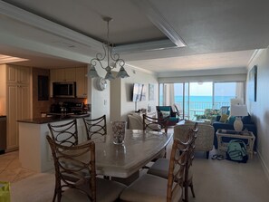 A spacious living area with a large dining table, comfortable seating, and a view of the ocean. - LUXURY BEACHFRONT Condo - Naples Continental Club (Naples)