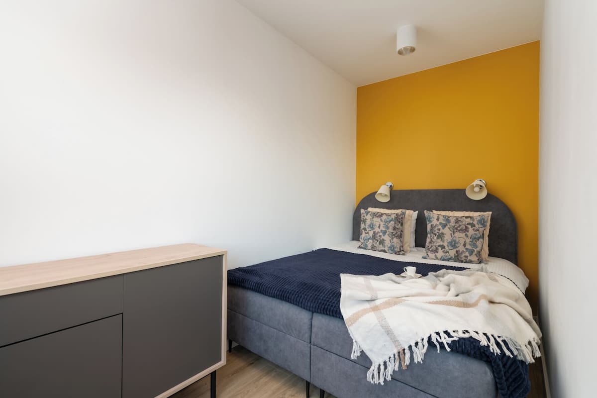 Un dormitorio con cama, mesita de noche y armario.