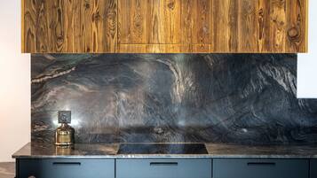 Una cocina con salpicadero de madera y encimera de mármol.