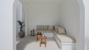 A minimalist living room with a sofa, two wooden tables, a potted plant, and decorative lanterns. - Avanoa Villa (Canggu)