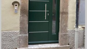 A green door with a decorative arch above it, set in a stone wall. - DOMUS TUSCIA APARTMENTS Via Estrema 2 (Viterbo)