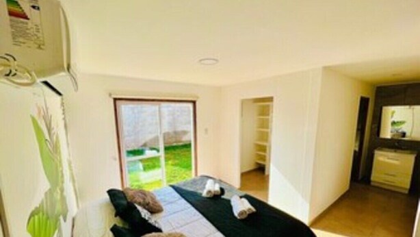 Un dormitorio con cama, baño y zona de cocina.