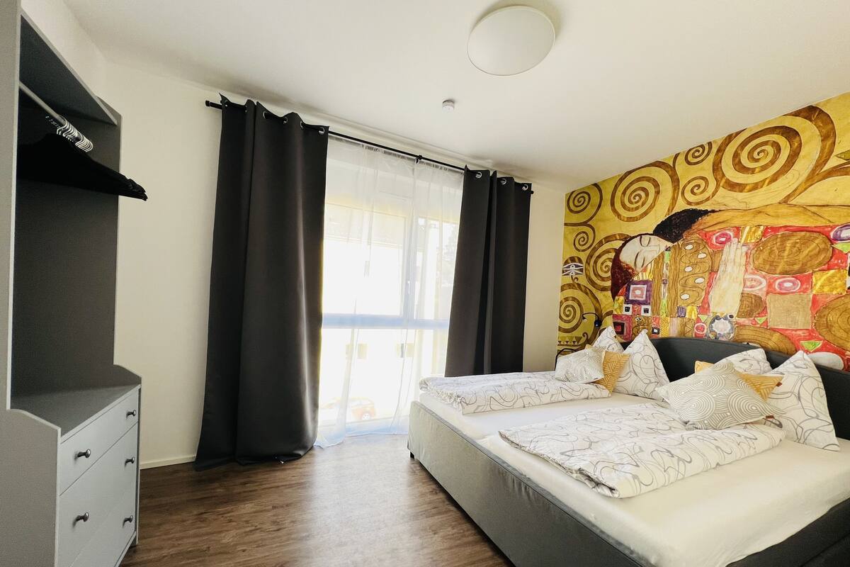 Un dormitorio con cama, cómoda y un ventanal con cortinas.