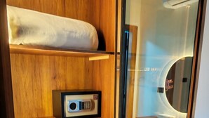 Una estantería de madera con una radio, una puerta de vidrio y una alfombra estampada.