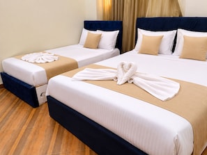 Two twin beds with white linens and beige accents, a heart-shaped towel on the larger bed, and a folded towel on the smaller bed. - ZEINA PYRAMIDS VIEW HOTEL (Giza)