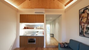 A modern kitchen with wooden beams, a built-in oven, and a countertop with various items.