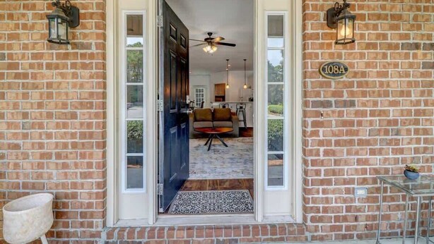 Une façade en briques avec une porte donnant sur un espace intérieur.