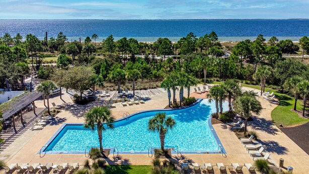 A resort with a swimming pool, lounge chairs, and a view of the ocean. - 🏖️1st Row Beach House🌴6 Seat Golf Cart 🌊OceanView Pools🏝️Beach Equip🔥Patio-Firepit (Port St. Joe)