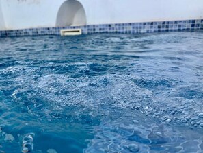 A pool with visible water activity and a tiled edge. - Casa Rural Sierra Tórtola 1 (Hinojales)