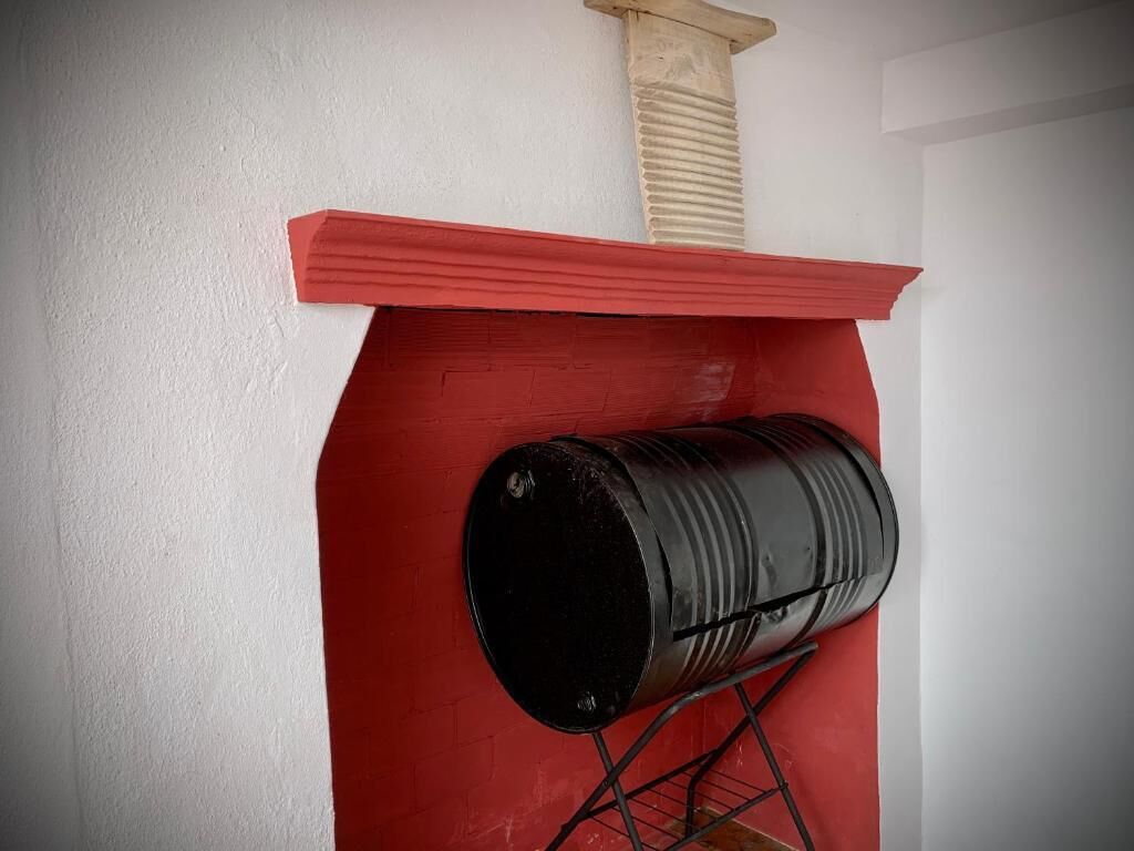 A red fireplace with a black barrel.