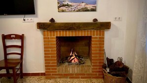 Una chimenea con un revestimiento de ladrillo, un fuste de madera y un televisor montado encima.