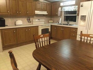 Enjoy cooking in this well-equipped kitchen with a central island, stove, oven, and refrigerator.