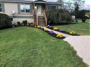 Welcome to a charming home with a beautifully manicured lawn and vibrant flower beds.