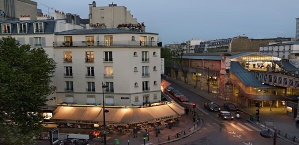 A street view with a building featuring a restaurant named "Le Pierrot" with outdoor seating.