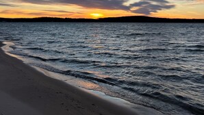 A beach with waves at sunset.