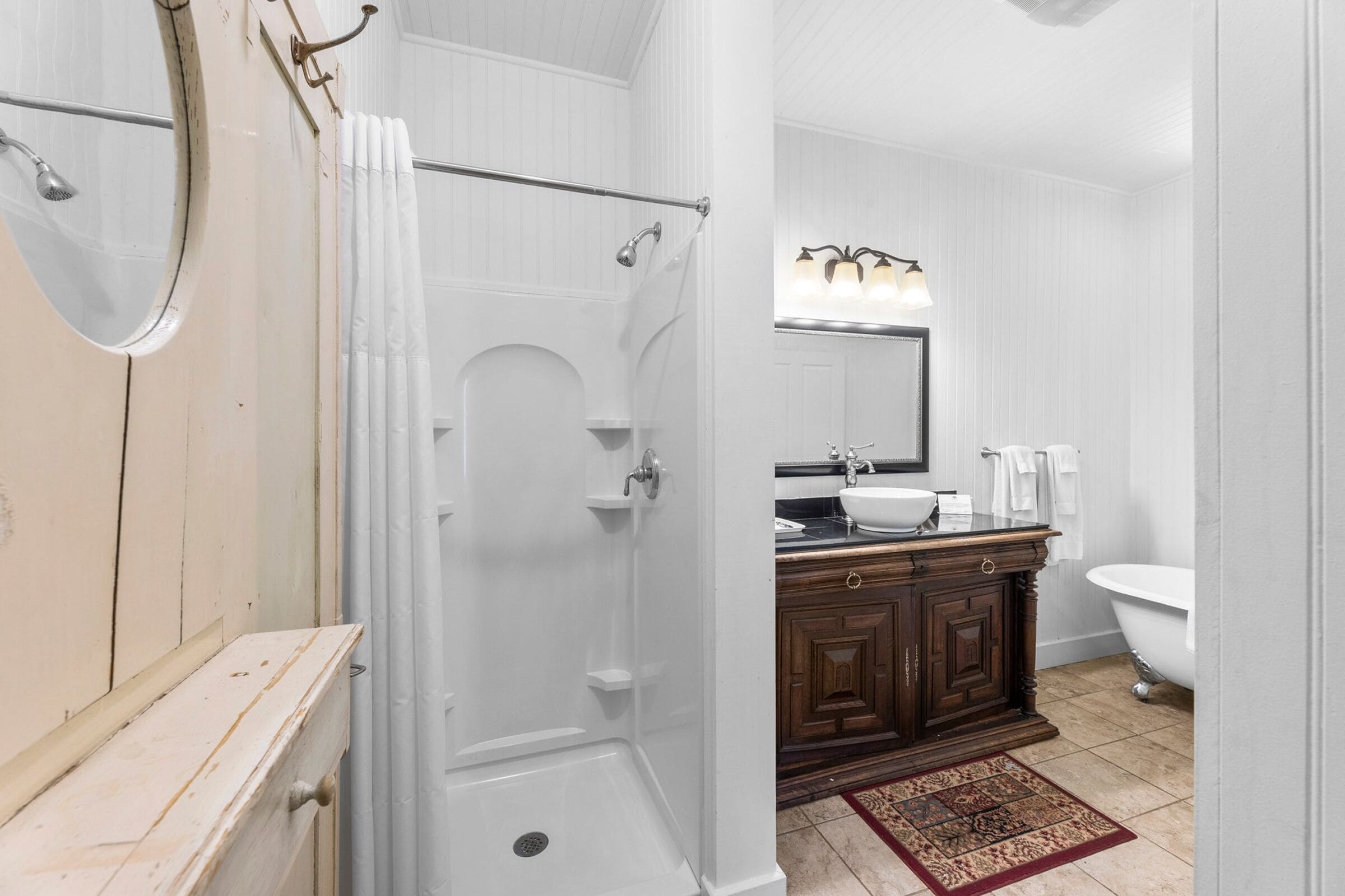 A bathroom with a shower, a sink, a toilet, and a mirror.