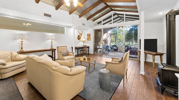 A spacious living room with a high ceiling, a fireplace, and a large window offering a view of the outdoors. - Meyer Hotel (Comfort)