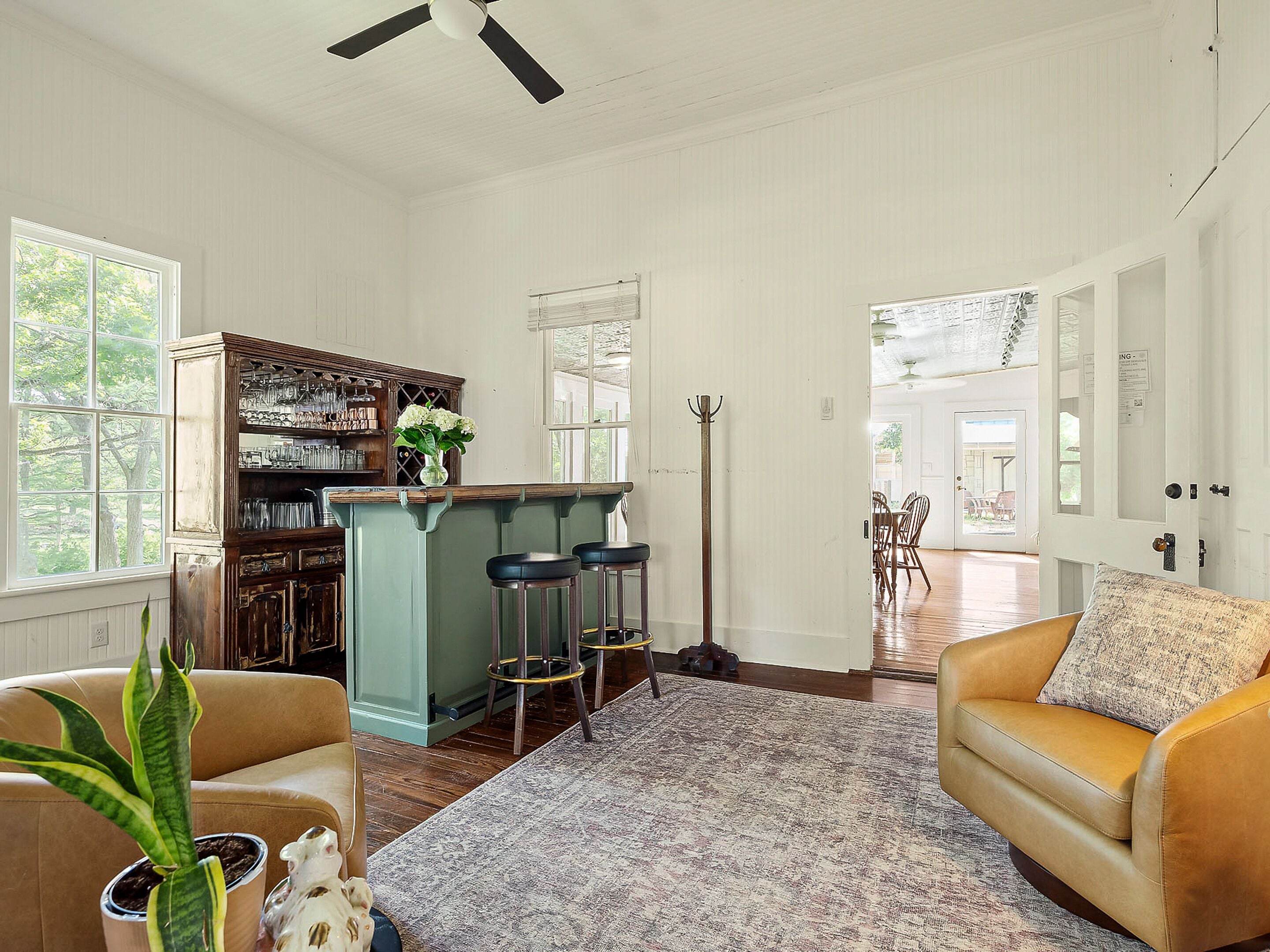 A spacious living room with a large window, a bar area, and a dining area.