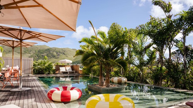A pool area with lounge chairs, umbrellas, and inflatable rings. - Le Martin Boutique Hôtel (Cul de Sac)