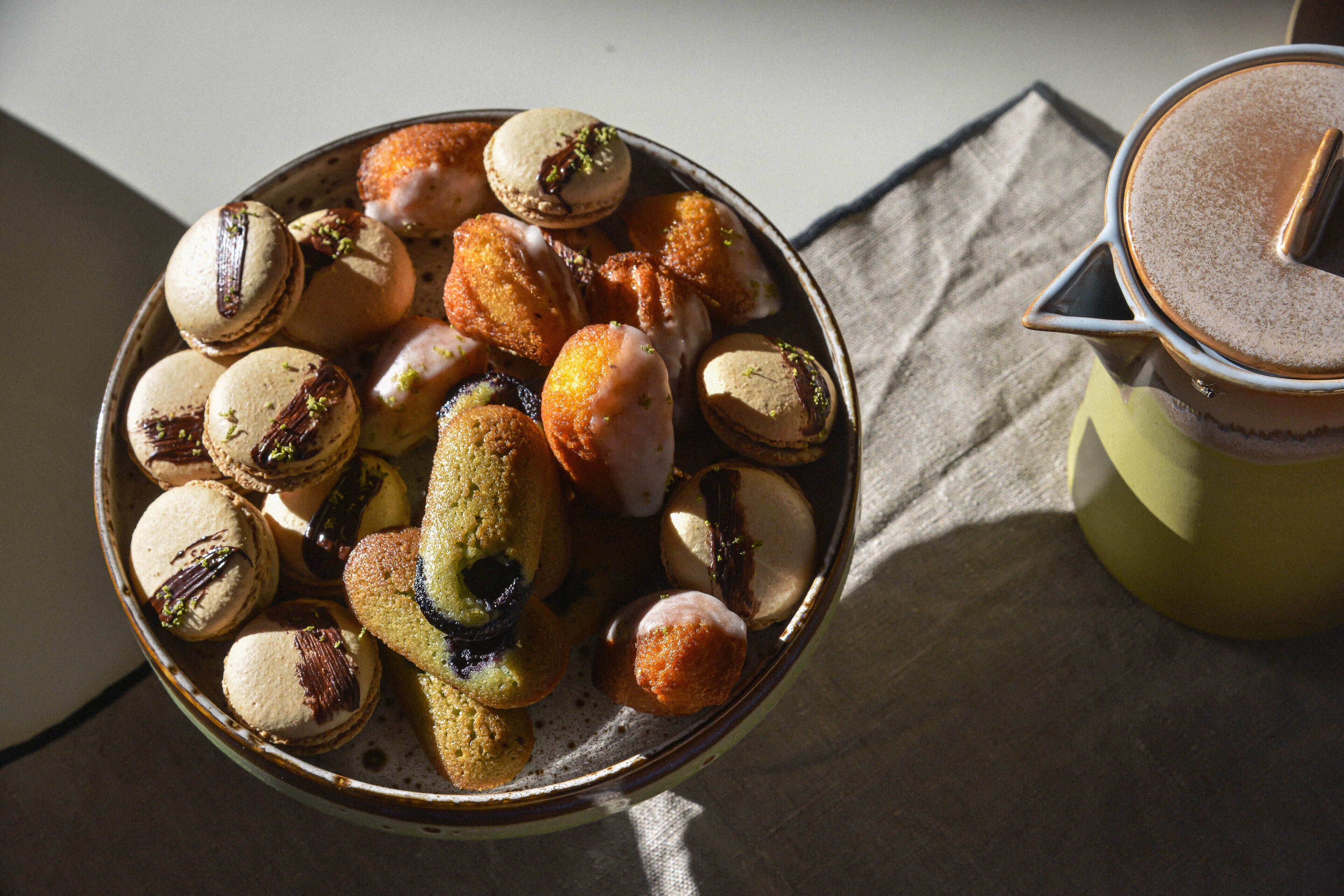 A bowl of assorted pastries and a cup of coffee on a table.