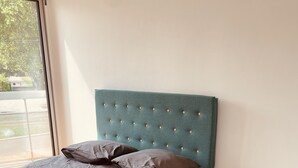 Ein Schlafzimmer mit einem Bett, einem weißen, flauschigen Teppich und einem kleinen weißen Tisch.