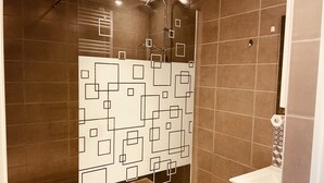 Ein modernes Badezimmer mit Duschbereich, Toilette und Waschbecken.