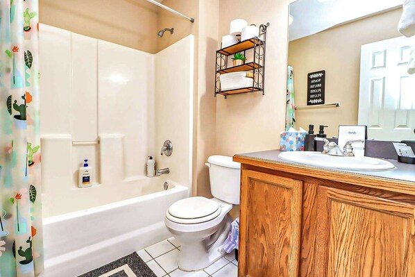 Une salle de bain avec une baignoire, des toilettes et un meuble-lavabo avec un évier.