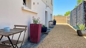 A patio with a table and chairs, potted plants, and a gravel pathway. - Tours-Fondettes - Touraine Loire Valley (Fondettes)
