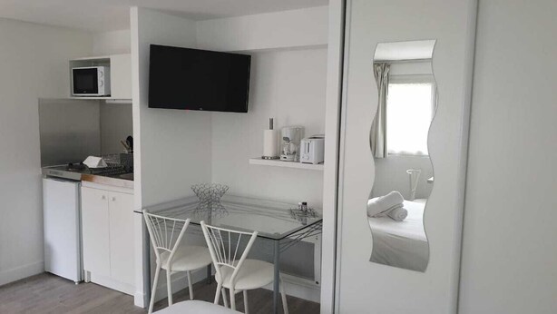 A compact kitchen with a microwave, a flat-screen TV, a coffee maker, and a small dining table with chairs. - Tours-Fondettes - Touraine Loire Valley (Fondettes)