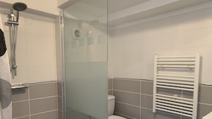 A modern bathroom with a glass shower enclosure, a white toilet, and a towel rack. - Tours-Fondettes - Touraine Loire Valley (Fondettes)
