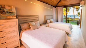 Une chambre d’h ôtel avec deux lits, une table de chevet, une commode et un tableau au mur.
