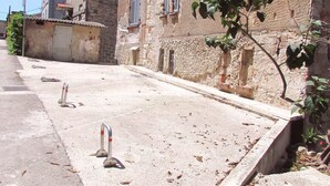 A street with a building featuring a stone facade, shutters, and a small garden area. - TRAVELLER FRIENDLY APARTMENT IN SUNNY PULA CITY IN BEAUTIFUL ISTRIAN COUNTY (Pula)