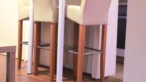 A bar area with three high stools and a wooden table. - TRAVELLER FRIENDLY APARTMENT IN SUNNY PULA CITY IN BEAUTIFUL ISTRIAN COUNTY (Pula)