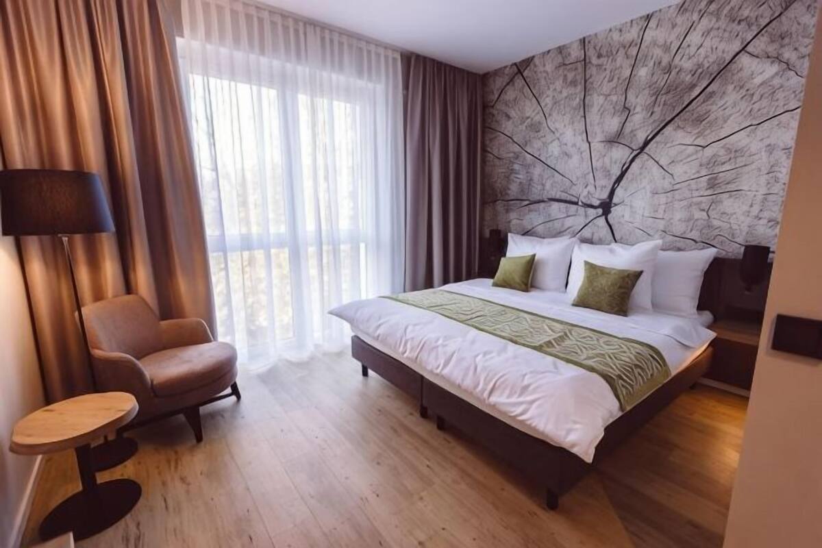 Une chambre d’hôtel avec un lit, une chaise, une table et une vue sur l’extérieur.