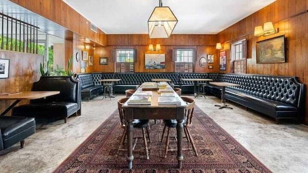 A spacious room with a long table and multiple seating options, including a bench and chairs.