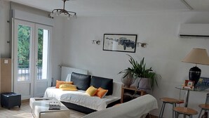 Un soggiorno moderno con un divano, un tavolino in vetro e un'area pranzo con sgabelli.