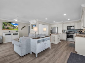 A modern kitchen with white cabinetry, a built-in oven, and a microwave.