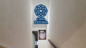Una escalera que conduce a una puerta con un cuadro enmarcado encima.