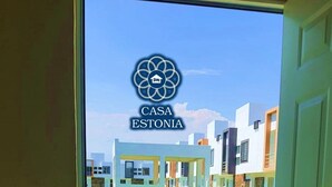 Un edificio moderno con un logotipo que dice "CASA ESTONIA" y vistas a un césped cuidado y un camino.