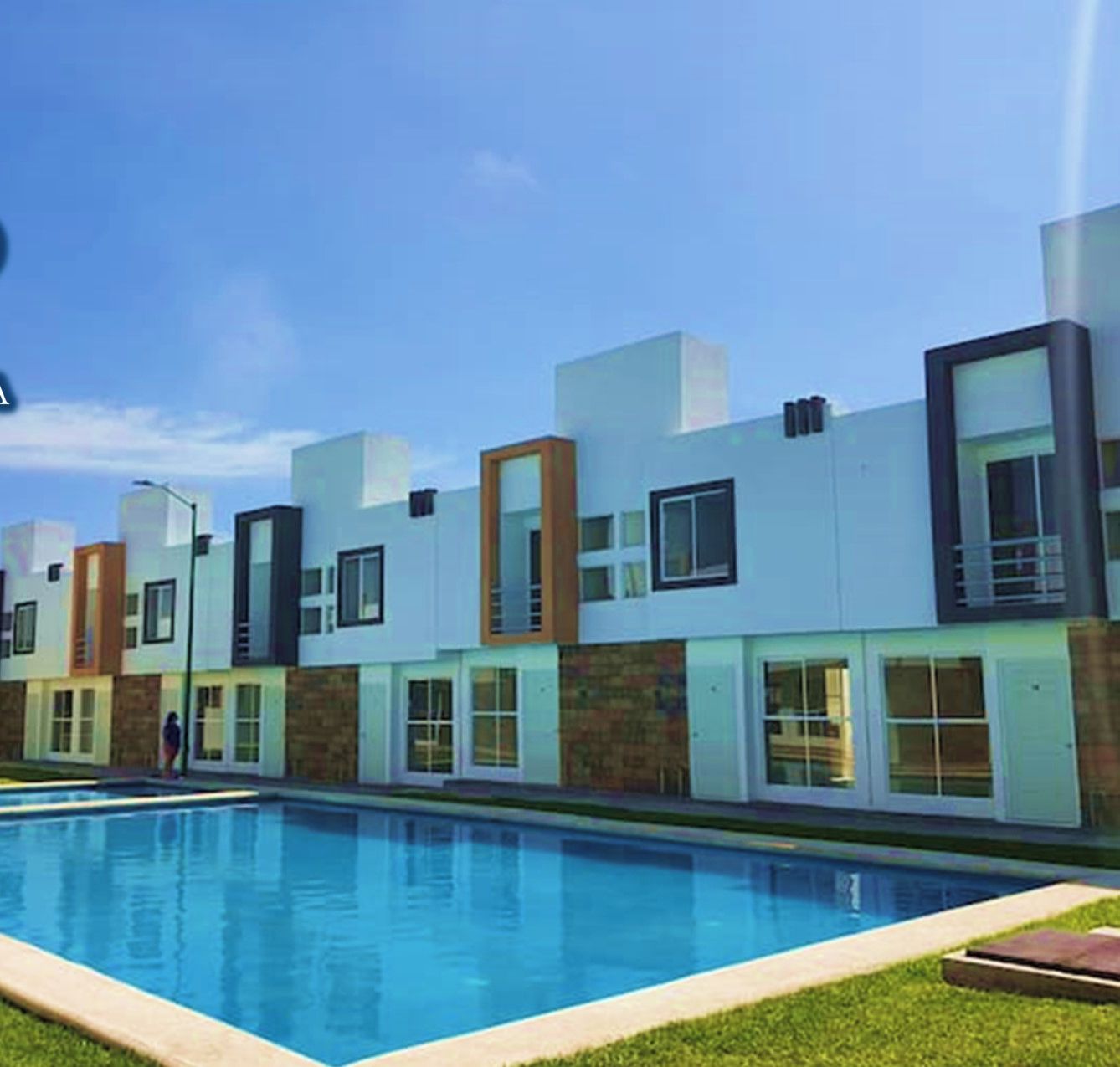 Un immeuble résidentiel moderne doté d’une piscine, avec une façade aux couleurs contrastées, mêlant le blanc et le brun, et un logo comportant le texte « CASA ESTONIA ».