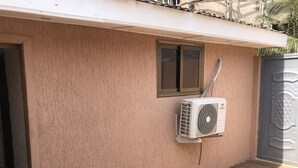 Een airconditioningunit aan een muur bevestigd, met een raam erboven.