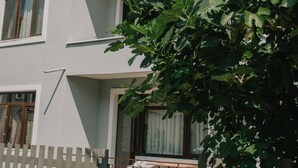 A two-story building with a white facade, a balcony on the upper floor, and a wooden fence in the foreground. - Agva Marina House (Sile)