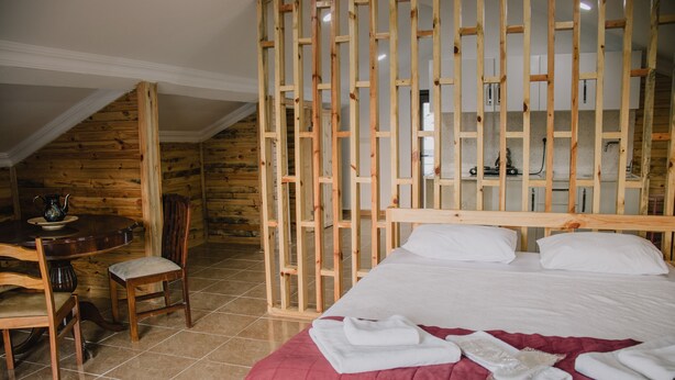 A bedroom with a wooden headboard, a bed with white linens, a red bedspread, and a wooden chair. - Agva Marina House (Sile)