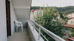 A balcony with a view of a residential area, a door, and a white chair. - Agva Marina House (Sile)