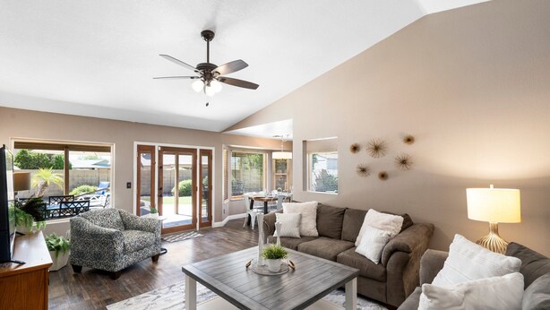 A spacious living room with a ceiling fan, a sofa, a coffee table, and a TV. - HUGE, heated pool. Family friendly, toys for all!  Big & beautiful backyard!  (Mesa)