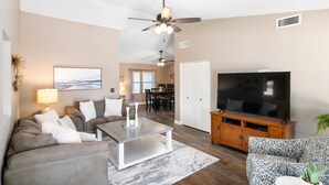 A living room with a sofa, coffee table, TV, and ceiling fan. - HUGE, heated pool. Family friendly, toys for all!  Big & beautiful backyard!  (Mesa)
