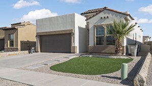 A modern house with a garage, a well-maintained lawn, and a palm tree. - Unique and Secluded home, traffic-free and quite (El Paso)